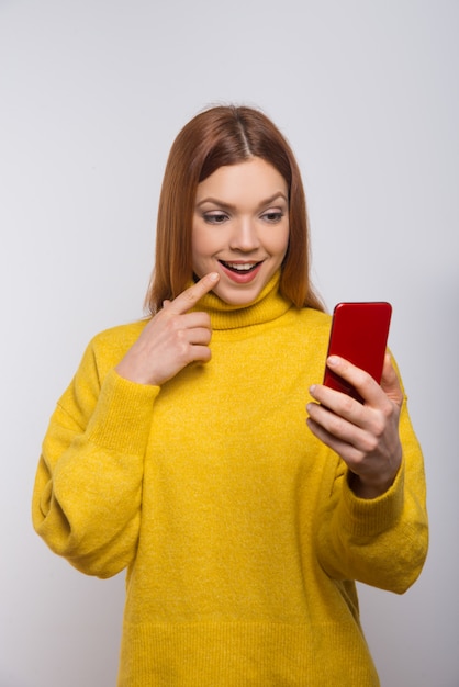 Mujer joven sonriente que usa smartphone