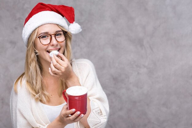 Foto gratuita mujer joven sonriente con sombrero de navidad