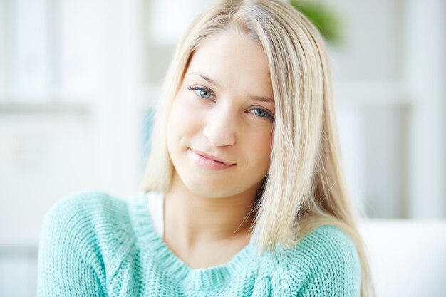 Mujer joven sonriente con suéter verde