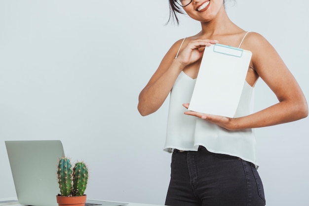 Foto gratuita mujer joven sonriente sujetando una carpeta