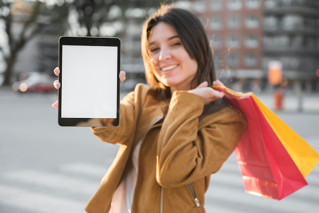 Foto gratuita mujer joven sonriente con la tableta