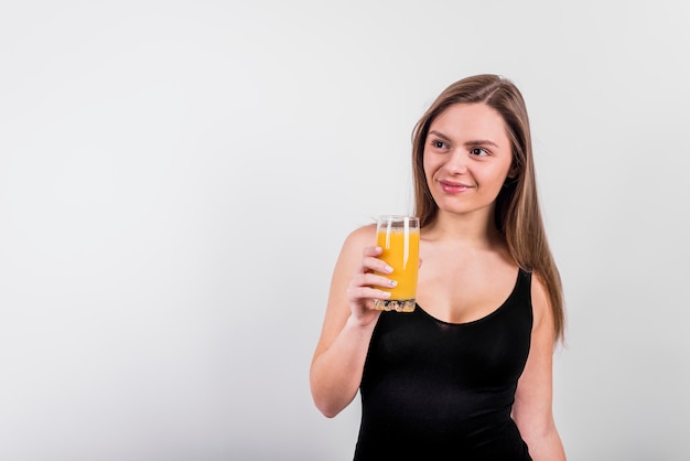 Mujer joven sonriente con vaso de jugo