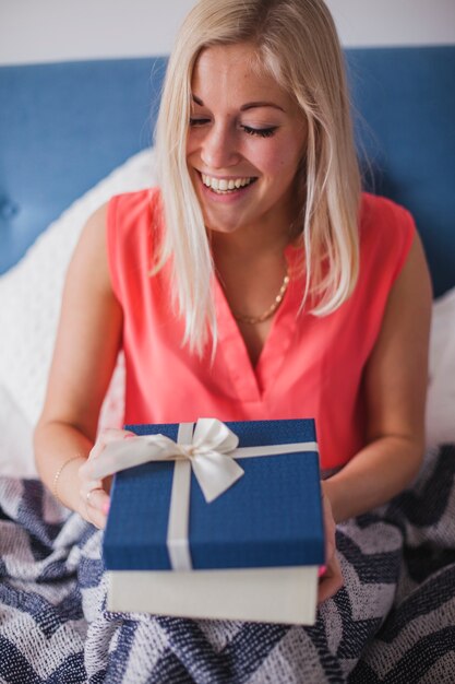 Mujer joven con una sonrisa bonita sujetando un regalo