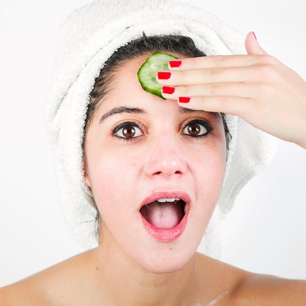 Foto gratuita mujer joven sorprendida con una rodaja de pepino en la frente