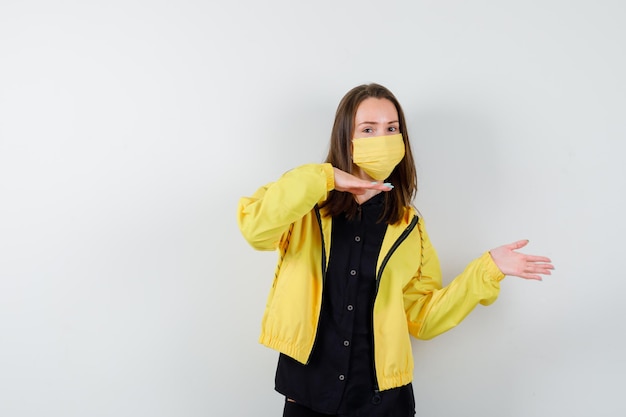 Mujer joven sosteniendo algo imaginario y apuntando a él