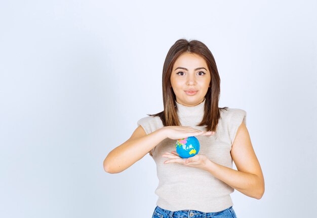 Mujer joven sosteniendo una bola de globo terráqueo