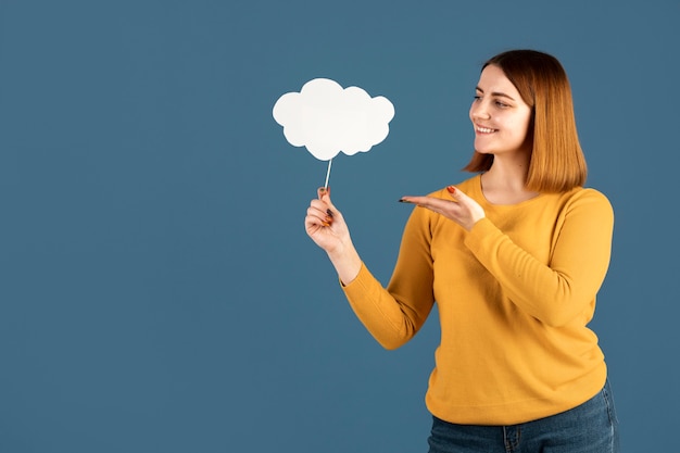 Foto gratuita mujer joven sosteniendo una burbuja de pensamiento con espacio de copia