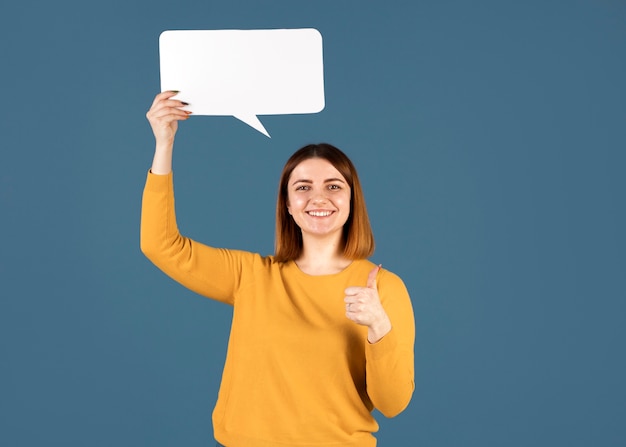 Mujer joven sosteniendo una burbuja de pensamiento