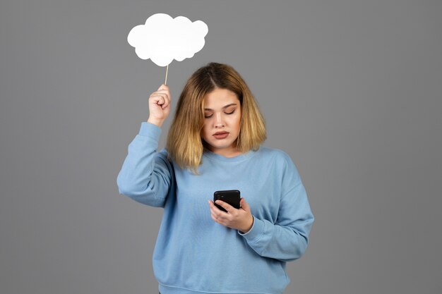 Mujer joven sosteniendo una burbuja de pensamiento