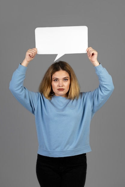 Foto gratuita mujer joven sosteniendo una burbuja de pensamiento