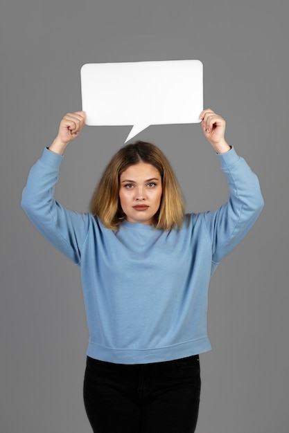 Mujer joven sosteniendo una burbuja de pensamiento