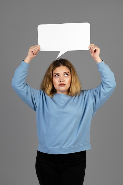 Mujer joven sosteniendo una burbuja de pensamiento