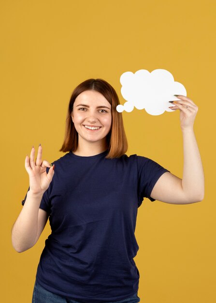 Mujer joven sosteniendo una burbuja de pensamiento