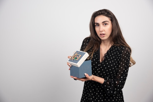 Mujer joven sosteniendo una caja azul vacía