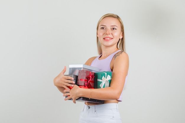 Mujer joven sosteniendo cajas de regalo en camiseta