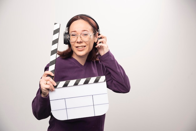 Mujer joven sosteniendo una cinta de cine sobre un fondo blanco. Foto de alta calidad