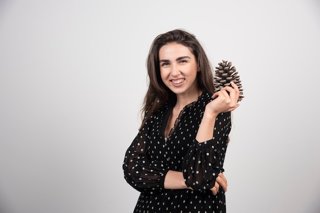 Mujer joven sosteniendo una gran piña