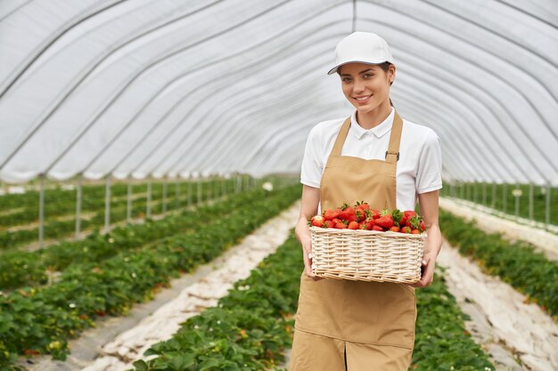 Mujer joven sosteniendo grandes deliciosas fresas rojas