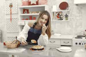 Foto gratuita mujer joven sosteniendo pastel casero en la cocina