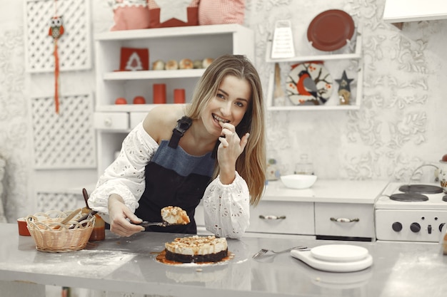 Mujer joven sosteniendo pastel casero en la cocina