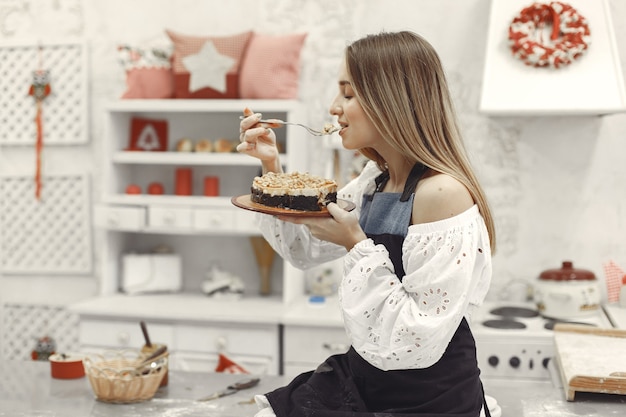 Mujer joven sosteniendo pastel casero en la cocina