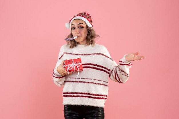 mujer joven sosteniendo pequeño presente en rosa