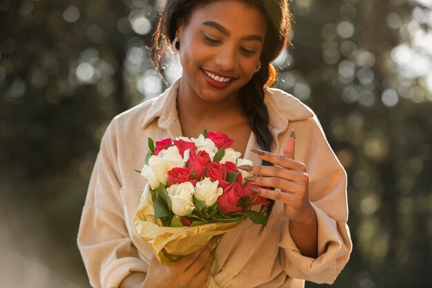 Mujer joven sosteniendo un ramo de rosas de su novio