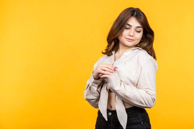 Mujer joven sosteniendo sus manos juntas y mirando hacia otro lado Foto de alta calidad