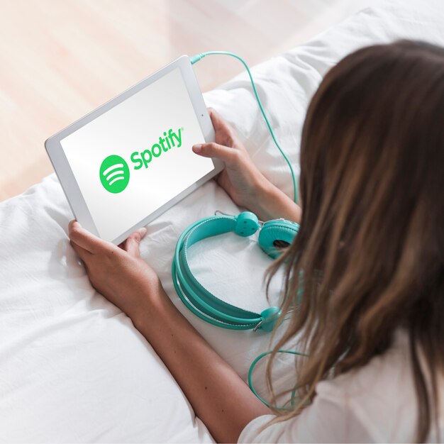 Mujer joven sosteniendo tablet con app de spotify