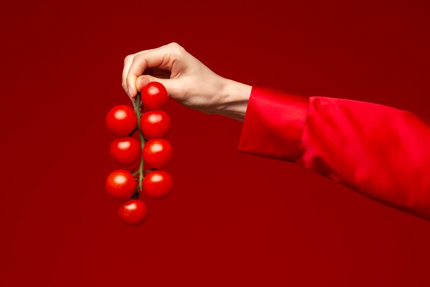 Mujer joven sosteniendo tomates cherry