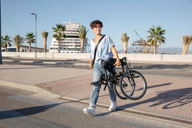 Mujer joven con su bicicleta plegable