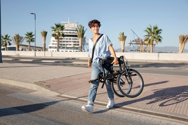 Mujer joven con su bicicleta plegable