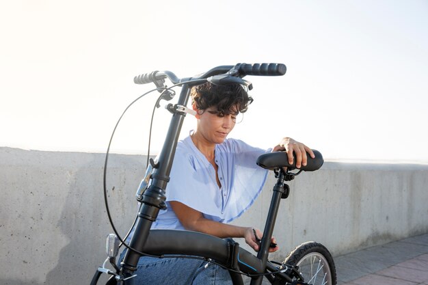 Mujer joven con su bicicleta plegable