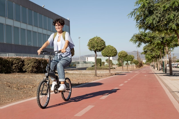 Foto gratuita mujer joven con su bicicleta plegable