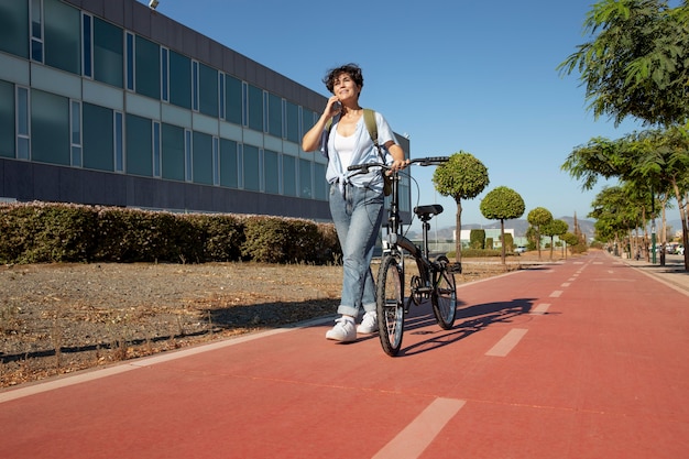 Mujer joven con su bicicleta plegable