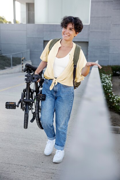 Mujer joven con su bicicleta plegable