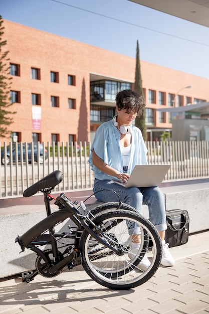 Foto gratuita mujer joven con su bicicleta plegable