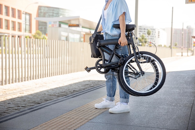 Mujer joven con su bicicleta plegable