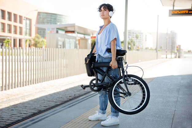 Mujer joven con su bicicleta plegable