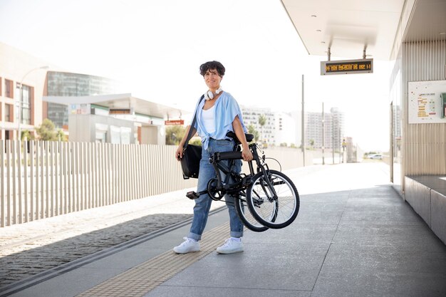 Mujer joven con su bicicleta plegable