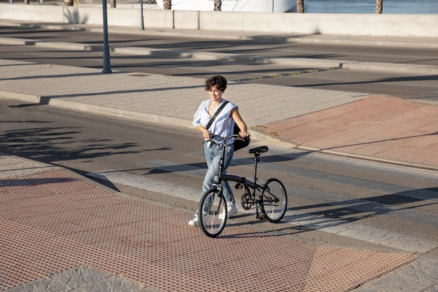 Mujer joven con su bicicleta plegable