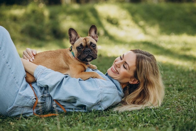 Mujer joven con su mascota bulldog francés en el parque