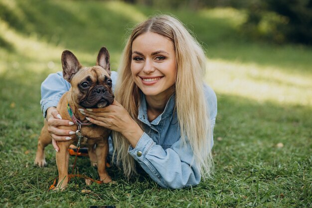 Mujer joven con su mascota bulldog francés en el parque