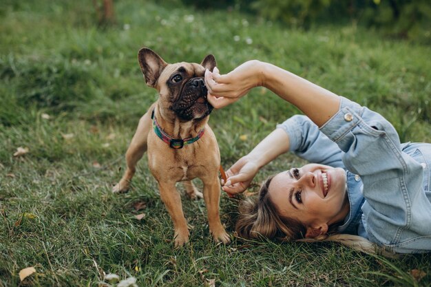 Mujer joven con su mascota bulldog francés en el parque