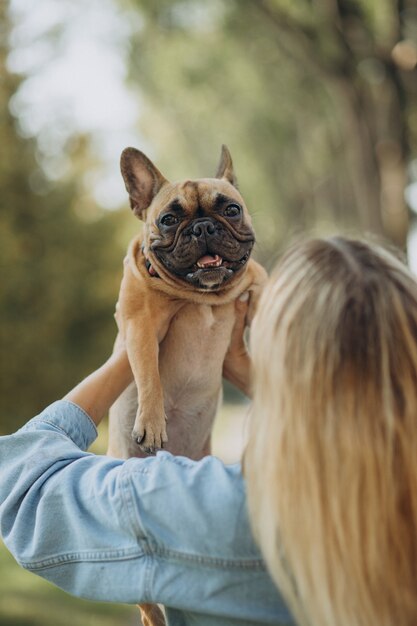 Mujer joven con su mascota bulldog francés en el parque