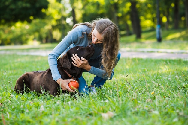 Foto gratuita mujer joven con su perro en el parque