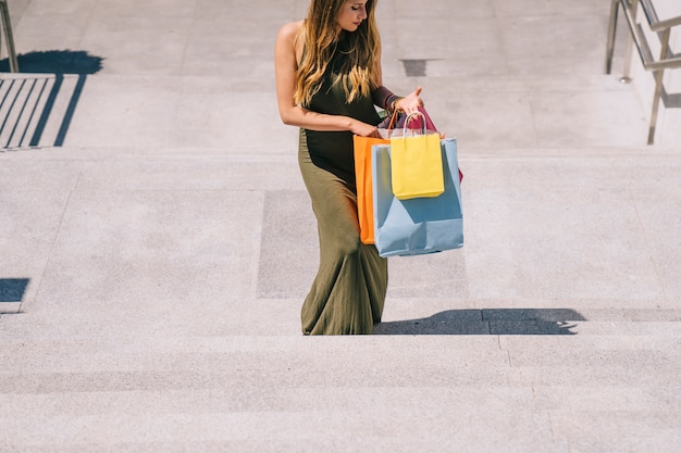 Foto gratuita mujer joven subiendo las escaleras tas las compras