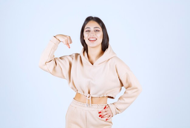 Mujer joven con una sudadera con capucha rosa que se siente fuerte y poderosa