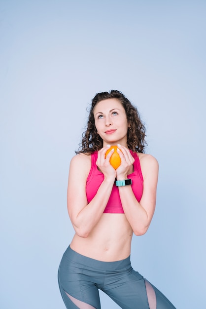 Mujer joven sujetando una naranja