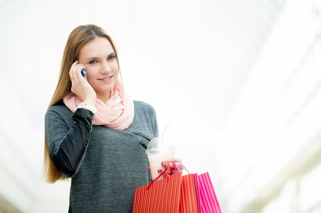 Mujer joven en el supermercado haciendo una llamada